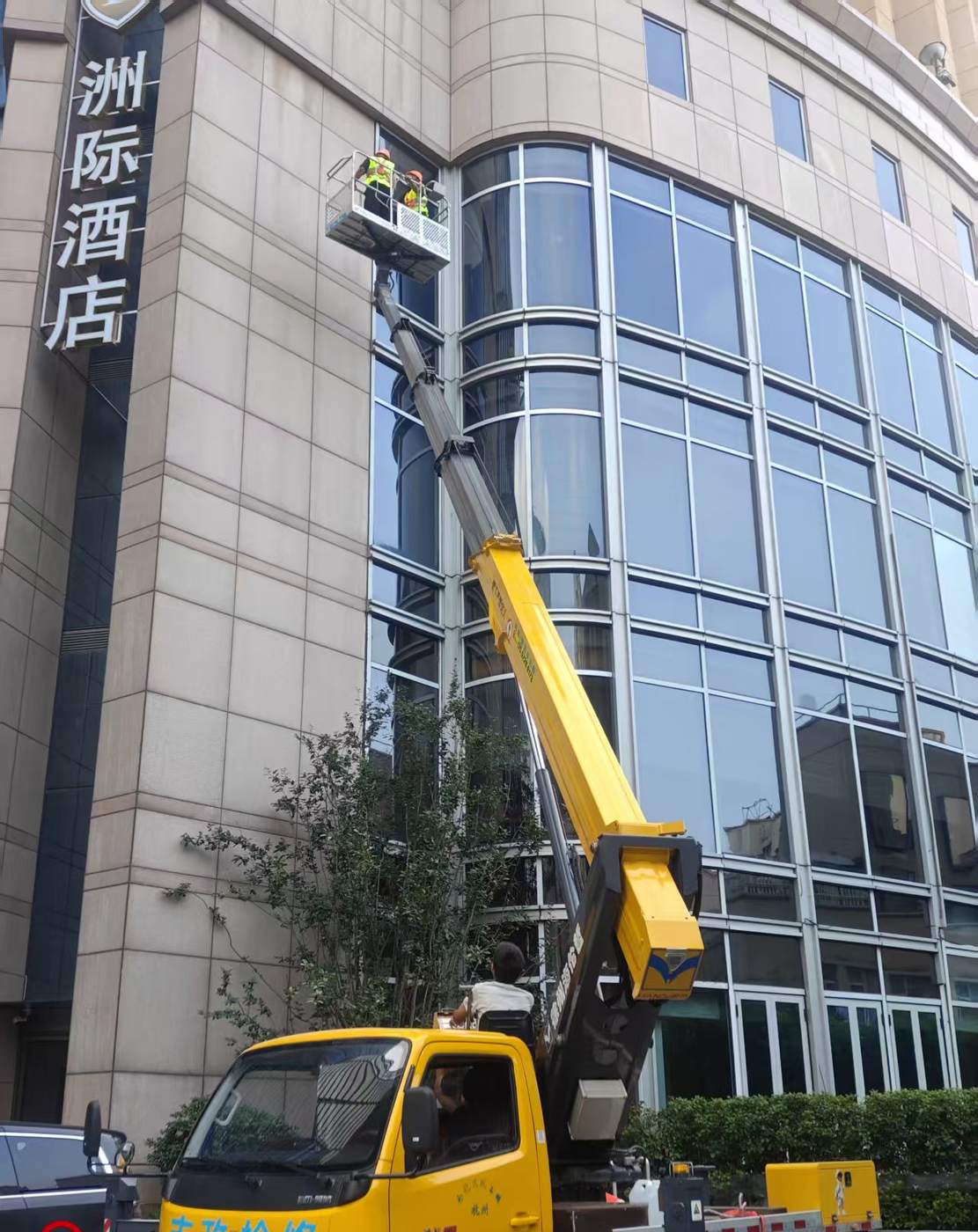 高空作业车安装玻璃幕墙施工现场实拍